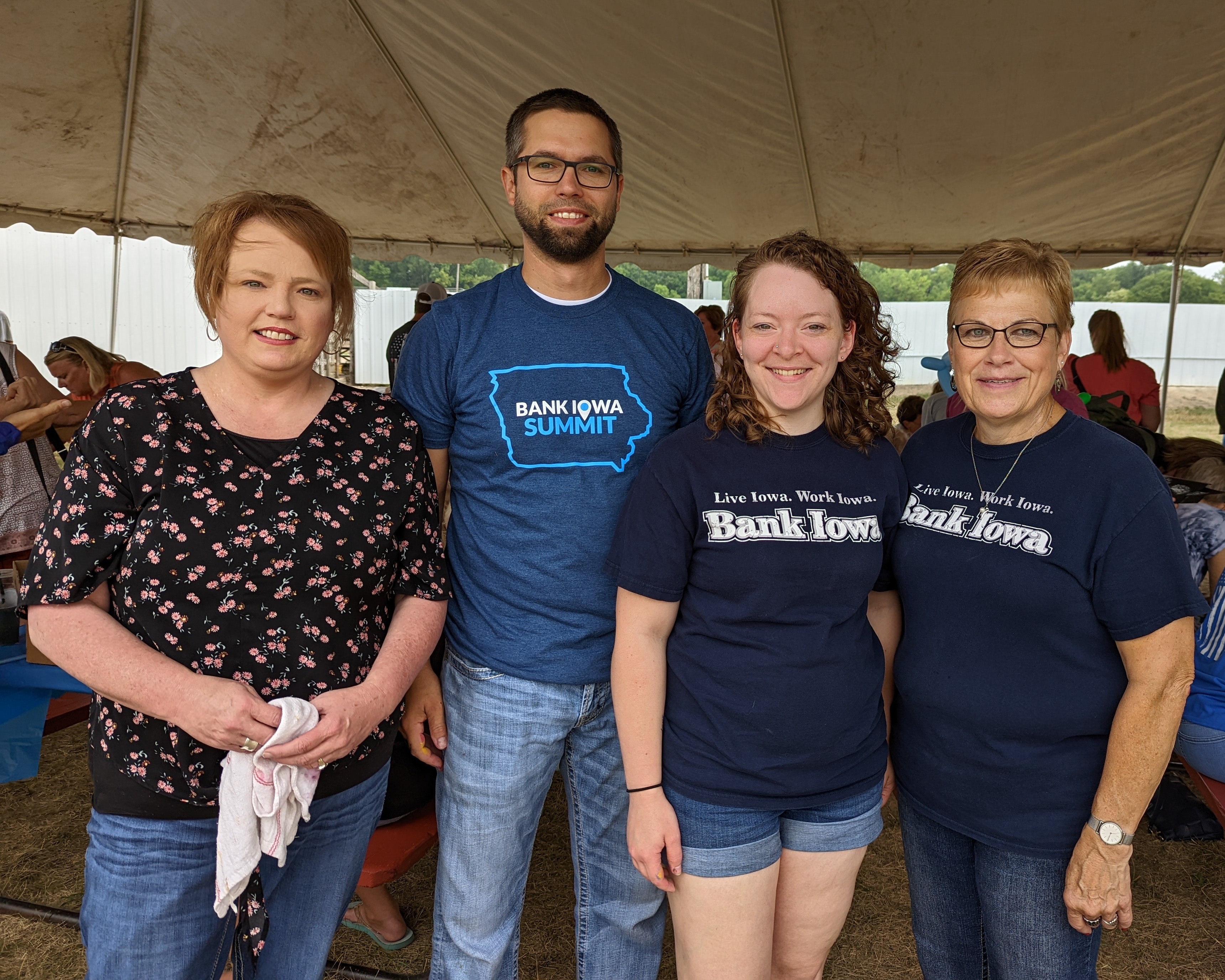 Four people standing together smiling