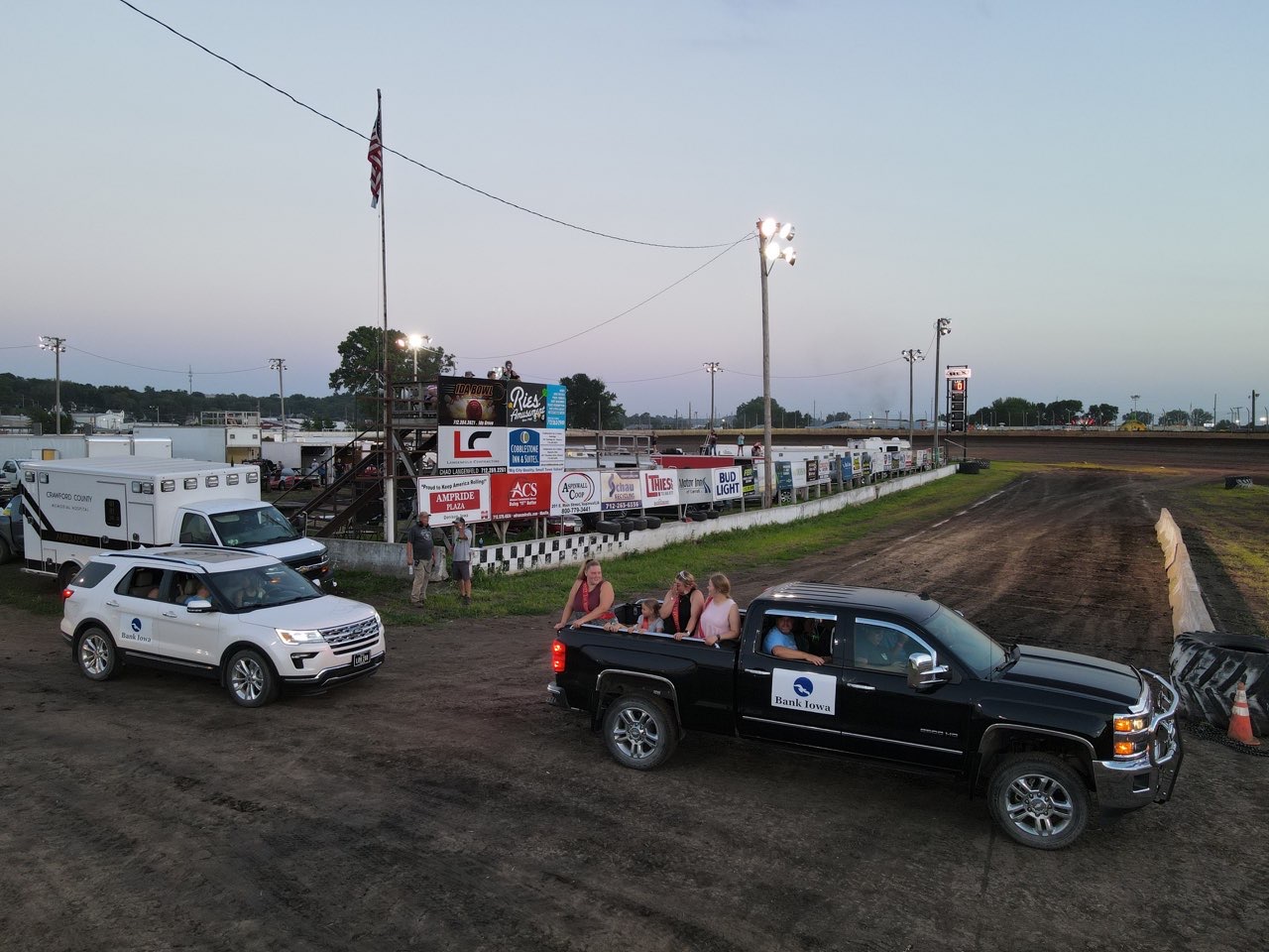 A truck and SUV with Bank Iowa logos at the speedway