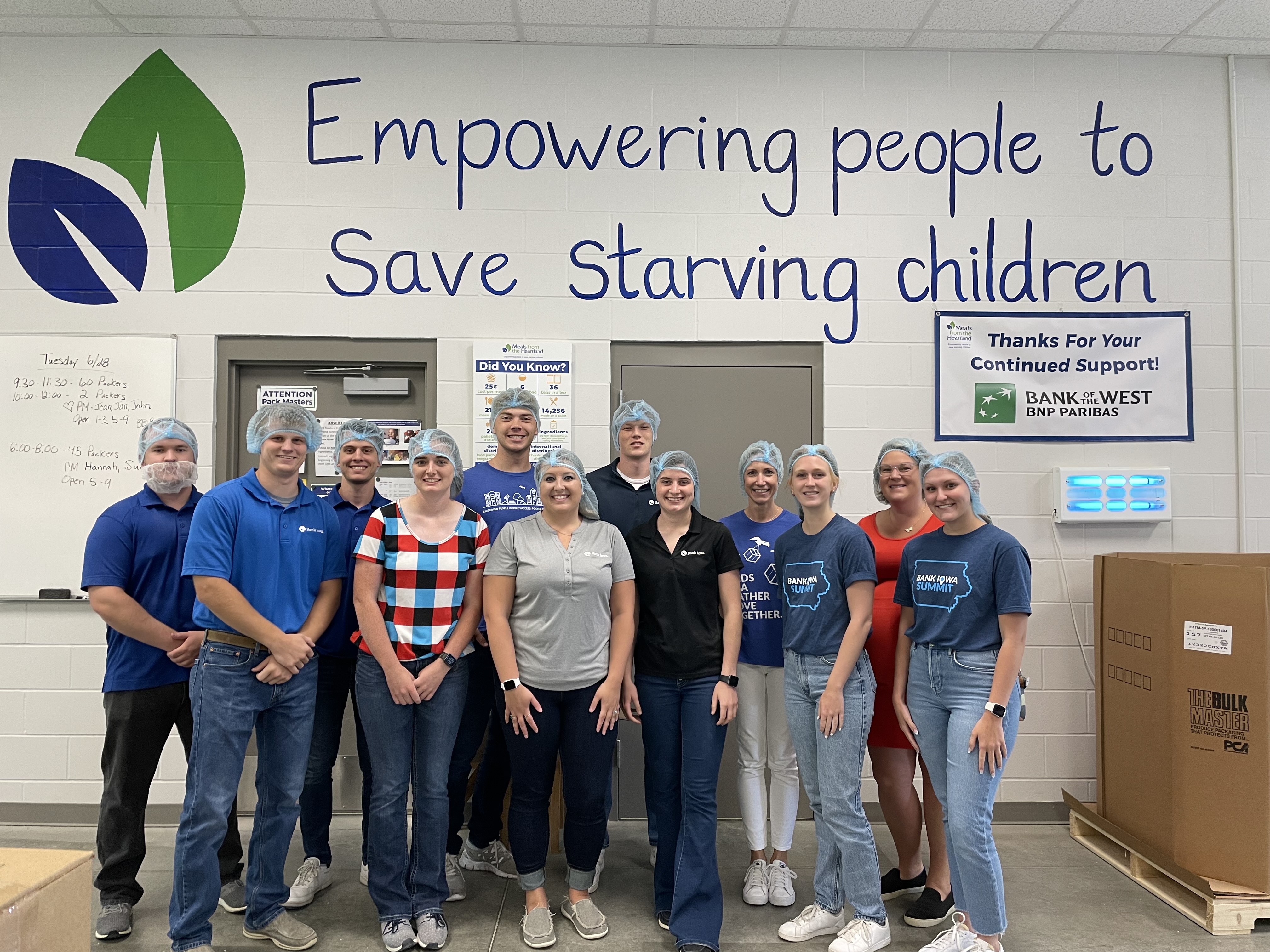 Group of people standing in a line smiling with hairnet