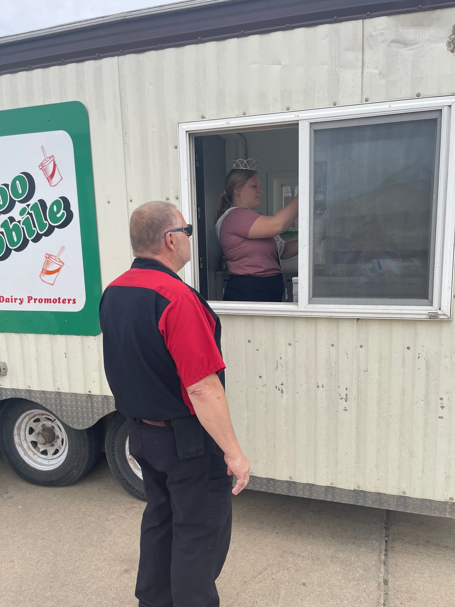 Man standing in front of ice cream truck with girl insi