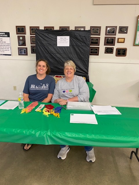 Two women sitting at a table smiling