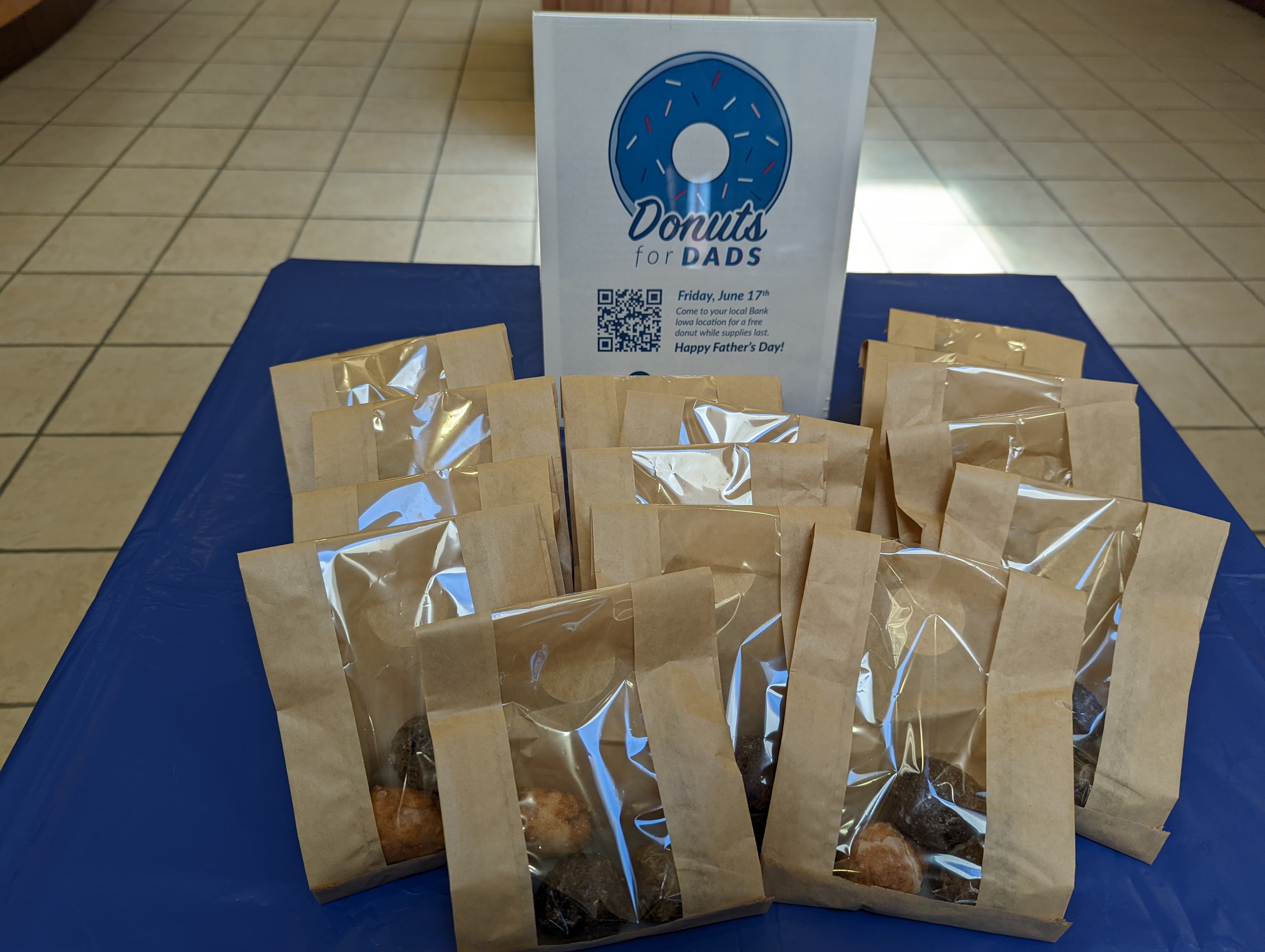 Bags of donut holes on a table with a "Donuts for Dads"